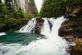 Strong stream of mountain waterfall in green forest - wide angle shot. Beautiful and power waterfall with turquoise water - stones Royalty Free Stock Photo