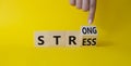 Strong Stress symbol. Businessman Hand points at turned wooden cubes with words Strong Stress. Beautiful yellow background. Royalty Free Stock Photo