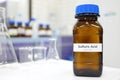 Strong sulfuric acid chemical in brown amber glass bottle inside a laboratory with copy space. Royalty Free Stock Photo