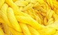 Strong thick braided colorful rope woven and twined. Yellow thick rope macro closeup laying in a heap. Long twisted