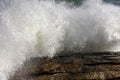 Strong wave breaking over rocks with water splashing in the air Royalty Free Stock Photo