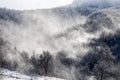 Strong wind blowing snow. Winter scene in mountains. Forest and hills covered with a snow. Snowy trees after heavy snowfall. Cold Royalty Free Stock Photo