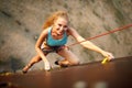 Strong woman and business success concept. Young caucasian pretty woman practicing climbing on artificial rock wall
