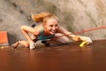 Strong woman and business success concept. Young caucasian pretty woman practicing climbing on artificial rock wall