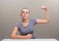 Strong woman flexes muscle, defiant