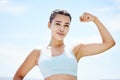 Strong woman flexing arms, body and muscle power, fitness and wellness training on blue sky Colombia outdoors. Portrait Royalty Free Stock Photo