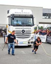 A strong woman pulls a heavy truck with a rope Royalty Free Stock Photo