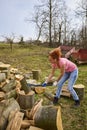 Strong woman splitting beech logs