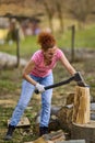 Strong woman splitting beech logs