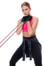 Strong woman using a resistance band in her exercise routine. Young woman performs fitness exercises on white background