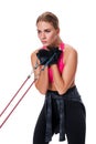 Strong woman using a resistance band in her exercise routine. Young woman performs fitness exercises on white background