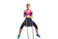 Strong woman using a resistance band in her exercise routine. Young woman performs fitness exercises on white background