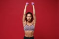 Strong young african american sports fitness woman in sportswear working out isolated on red background. Sport exercises Royalty Free Stock Photo