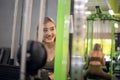 Strong young Asian woman exercising with pulldown machine in a fitness club, doing exercises in gym Royalty Free Stock Photo
