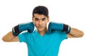 Strong young brunette man in blue gloves practicing boxing and looking at the camera isolated on white background Royalty Free Stock Photo