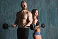Strong young couple working out with dumbbells. Royalty Free Stock Photo