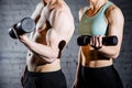 Strong young couple working out with dumbbells. Shot in studio on a white background Royalty Free Stock Photo