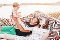 Strong young father holding his baby daughter in hands with happy hipster mother, smiling family relaxing in a hammock on a beach Royalty Free Stock Photo
