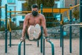 Strong young latin man doing calisthenics with mask