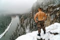 Strong young man with bare torso on mountain top covered with snow Royalty Free Stock Photo