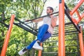 Strong young man doing amazing pull-up variation during extreme