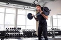 Strong young man doing heavy weight exercise for biceps