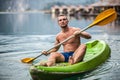 Strong young man in kayak on the picturesque lake in Thailand. Royalty Free Stock Photo