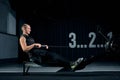 Strong young man in a t-shirt and shorts doing exercises on the simulators in the gym looking to the side Royalty Free Stock Photo