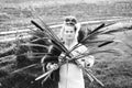 Strong young woman with a bulrush grass reed on rural field, portrait monochrome