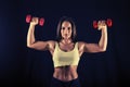 Strong young woman doing dumbbell push press