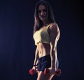 Strong fit young woman with dumbbells