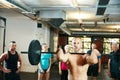 Stronger every day. a man lifting weights while a group of people in the background watch on. Royalty Free Stock Photo