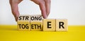 Stronger together symbol. Businessman turns cubes and changes the word together to stronger. Beautiful yellow table, white Royalty Free Stock Photo