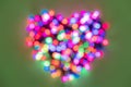 Strongly blurred rainbow lights folded in the shape of a heart on a green background for Valentines Day Royalty Free Stock Photo