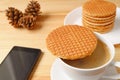 Stroopwafel Placed on Hot Coffee Cup with a Cellphone Royalty Free Stock Photo