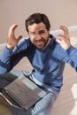 Strssed man sitting on floor using laptop Royalty Free Stock Photo