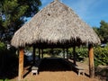 Structure or building with grass roof and wood benches