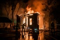 Structure engulfed in flames with firefighters in silhouette battling blaze Royalty Free Stock Photo