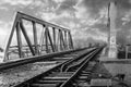 Structure of gray metal railway bridge for train in a sunny day. Old railway bridge over the water, in black and white Royalty Free Stock Photo