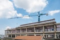 Structure of large building with worker working, crane and scaffold in construction site Royalty Free Stock Photo