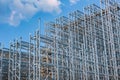 Structure of a new steel frame of a building on an industrial construction site. Against the background of a blue sky with clouds Royalty Free Stock Photo