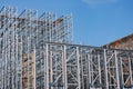 Structure of a new steel frame of a building on an industrial construction site. Against the background of the blue sky Royalty Free Stock Photo