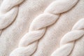 Structured geometric knitted texture in beige displays sharp directional lighting, highlighting its depth and creating a