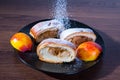 Strudel with apples on a black plate, peaches, close-up