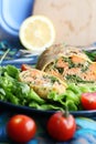 Strudel with salmon, lemon and arugula on blue background