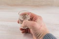 The struggle with addiction - alcoholism: a shot of vodka in the emaciated hand of an adult man, a moment of reflection. At the