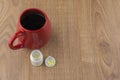 The struggle against Drowsiness : caffeine pills near the pill boxes and red Cup of strong coffee on wooden table Royalty Free Stock Photo