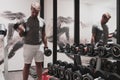 Struggling with age. Confident senior man exercising with dumbbells in health club. Selective focus Royalty Free Stock Photo