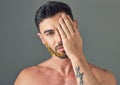 Struggling with bald patches in your beard. Studio shot of a handsome young woman posing with flowers in his beard. Royalty Free Stock Photo