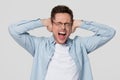 Stubborn angry young man covering his ears hearing annoying noise Royalty Free Stock Photo